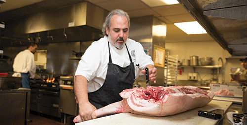 Chef Craig DiFonzo takes apart a Mulefoot hog in the Lungomare kitchen.